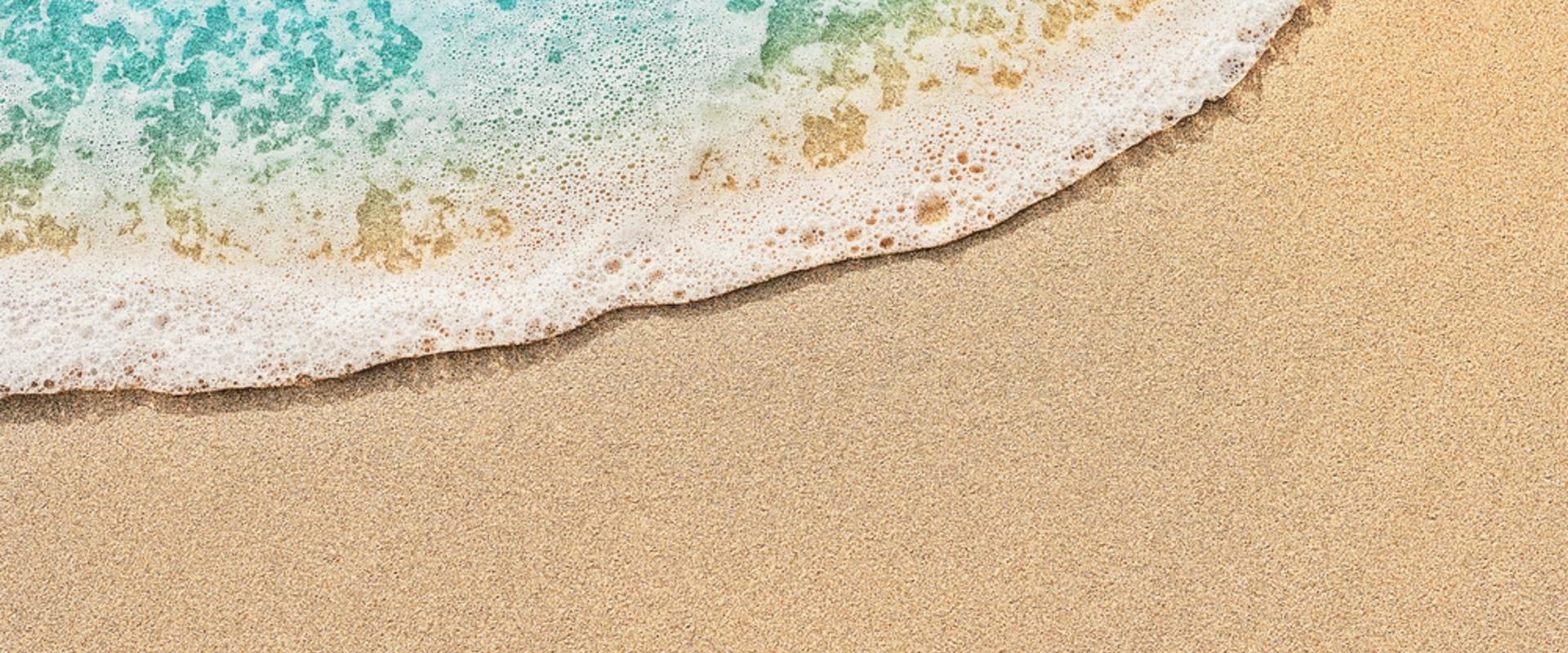 Top view of beach water meeting sand